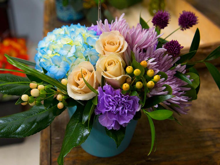 A lovely purple, blue and yellow arrangement in a glass vase