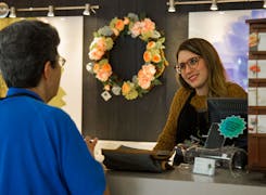 A member of the Eastern Floral staff, waiting to help at the customer service desk